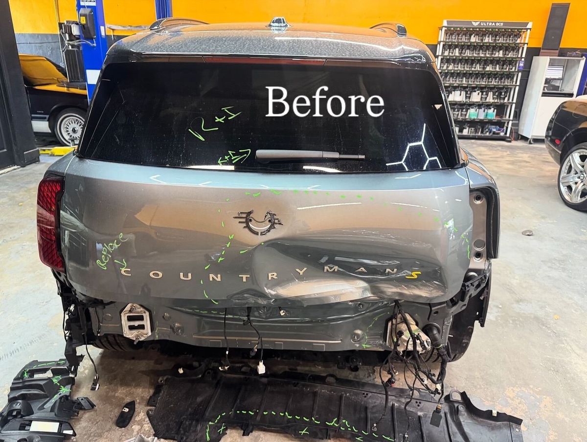 Gray Mini Countryman S with a dented liftgate and the rear bumper removed, damage marked in green, before repair at Gold Coast Collision Center